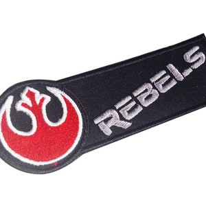 May include: A black and red embroidered patch with the Rebel Alliance symbol and the word "REBELs" in white.