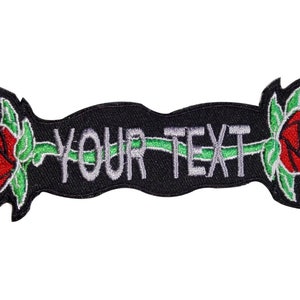 Könnte beinhalten: Schwarzer gestickter Aufnäher mit zwei roten Rosen und einem Banner mit der Aufschrift "YOUR TEXT" in Weiß.