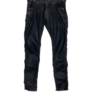 Könnte beinhalten: Schwarze Skinny Jeans mit Used-Look. Die Jeans hängen an einem Kleiderbügel.