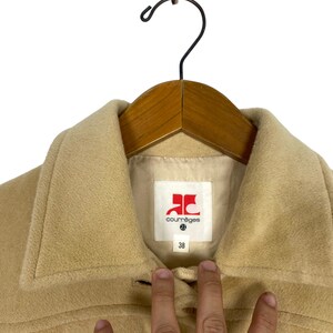 May include: A beige wool coat with a large red label that says "Courr&egrave;ges" and a size 38.