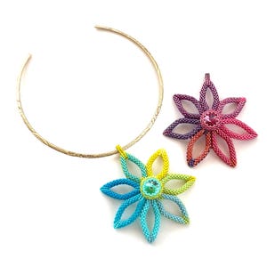May include: A gold-coloured choker necklace with a textured finish, alongside two beaded flower pendants. One pendant is a gradient of blue, green, and yellow, the other a gradient of pink, purple, and orange. Each flower has a central crystal.