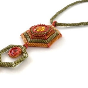 Pode incluir: Um colar de contas verdes, laranja e vermelhas com um pingente geométrico que apresenta uma pedra grande de cor âmbar.