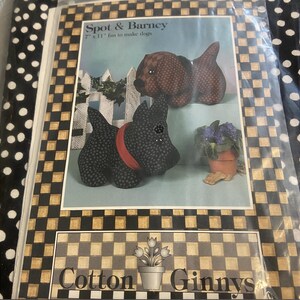 May include: A package featuring a dog-themed craft project. The image shows two stuffed dog figures, one black with a red collar and one brown. The text reads "Spot & Barney" and "7" x 11" fun to make dogs."