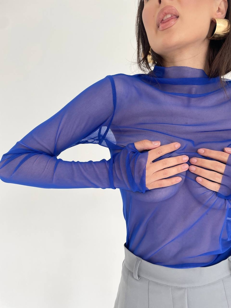 May include: A royal blue sheer long-sleeved top with a mock neck.