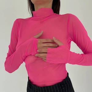 May include: A bright pink, sheer, long-sleeved shirt with a mock neck.