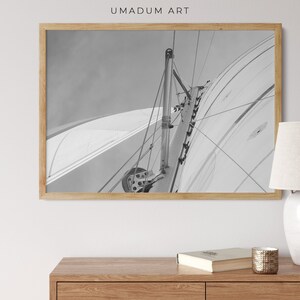 May include: A black and white photograph of a sailboat's mast and rigging. The image is taken from the deck of the boat, looking up at the mast.