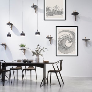 K&ouml;nnte beinhalten: Zwei schwarze gerahmte Drucke von Strichzeichnungen von Wellen auf cremefarbenem Hintergrund. Die Drucke h&auml;ngen an einer wei&szlig;en Wand in einem Esszimmer mit einem schwarzen Tisch und St&uuml;hlen. Der Text "UMADUM ART" befindet sich in der oberen rechten Ecke des Bildes. Der Text "CONTEMPORARY PRINTABLE ART | DIGITAL DOWNLOAD" befindet sich am unteren Rand des Bildes.