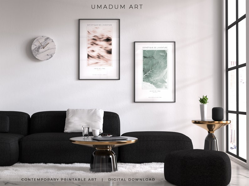 May include: Two abstract art prints with black frames, one with a pink and white design and the other with a green and white design. The prints are hanging on a white wall above a black sofa and a coffee table with a glass top. The text on the prints reads "Esthetique de l'aventure" and "Un air de liberte".
