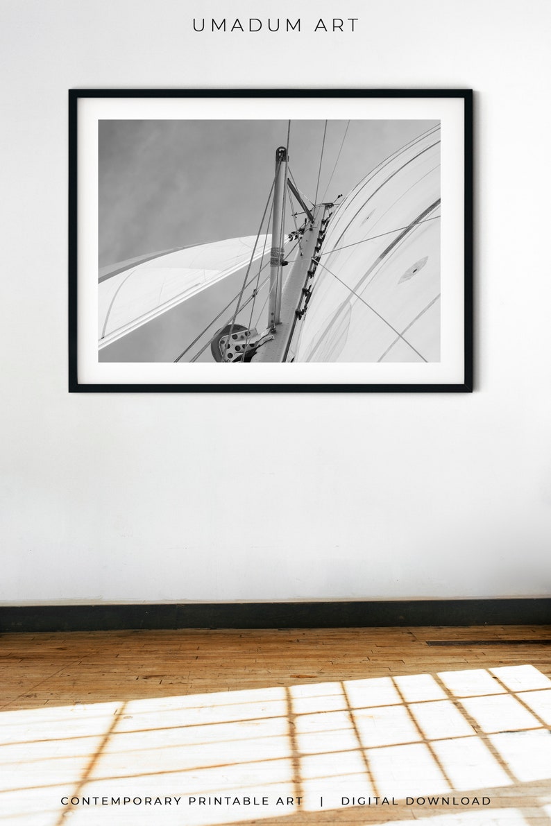 May include: Black and white photograph of a sailboat's mast and rigging against a cloudy sky.