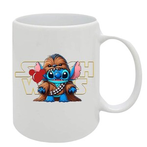May include: White ceramic mug featuring a cartoon Stitch character dressed as Chewbacca, holding a red balloon. The words "Star Wars" are in gold lettering behind the character. The mug has a curved handle.