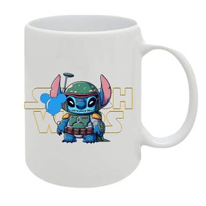 May include: White ceramic mug featuring a cartoon character dressed as a Star Wars bounty hunter. The character is blue with large ears and is wearing a green helmet. The words "Star Wars" are in gold lettering.