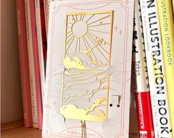 Marcador de metal dourado - Avião de papel no céu