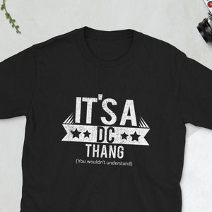 May include: Black t-shirt with white text that reads "It's a DC Thang (You wouldn't understand)".