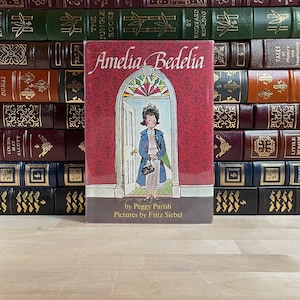 Amelia Bedelia por Peggy Parish, primera edición e impresión inicial, ilustrada por Fritz Siebel, sobrecubierta original, muy rara