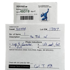 May include: A close-up of a white card with black text. The card is titled "Animation Art" and includes the text "Sale# 322204", "Lot ID# 13017", "No. of Items 1", "Description The Tick cel", "Photo Instructions 1 crop to character 2 full 3 lift naat, full 4", "Special Instructions (Detail, Extra Shots, Angles - BE SPECIFIC)", "Check with Jim Lentz Ext 1991", "Cataloger Name & Extension Carl T. 1939".