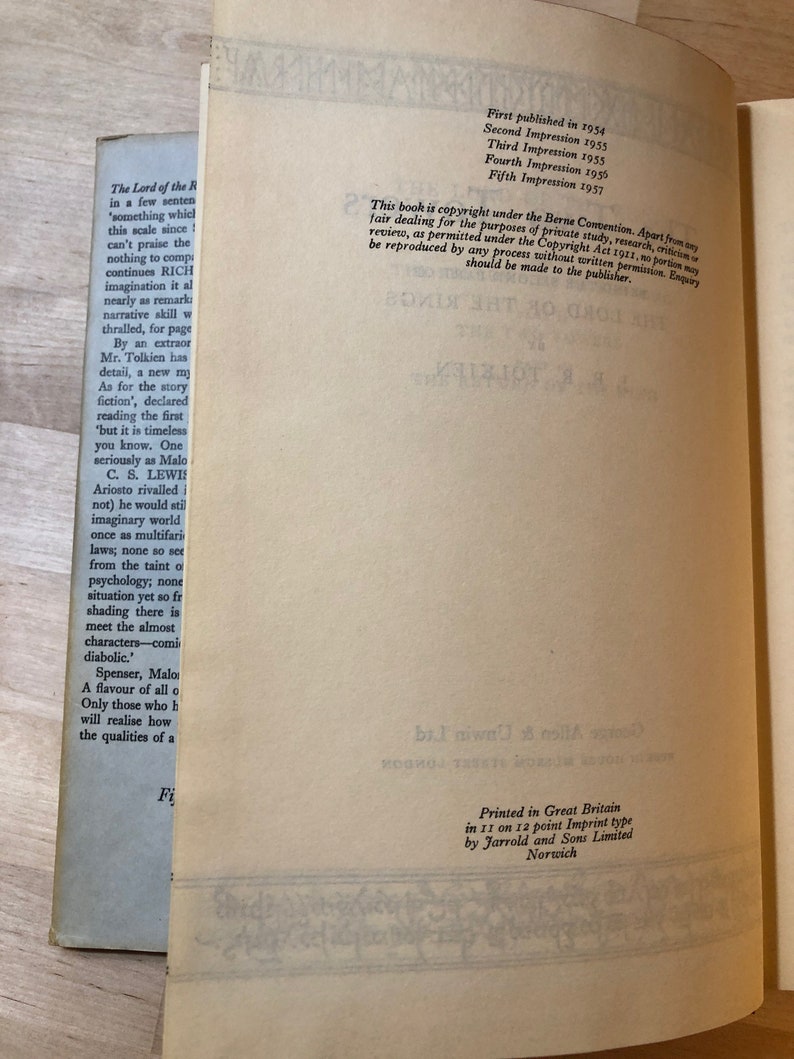 May include: A close-up of a book's copyright page with information about the book's publication history, including the first publication date, subsequent impressions, and copyright details. The text includes the title "The Lord of the Rings" and the author's name, J.R.R. Tolkien.