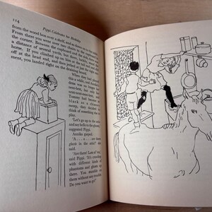 Puede incluir: Un libro abierto con ilustraciones en blanco y negro. Una p&aacute;gina muestra a una ni&ntilde;a sobre una caja, la otra representa a una ni&ntilde;a sobre un caballo alcanzando objetos en una cocina. El texto es visible.