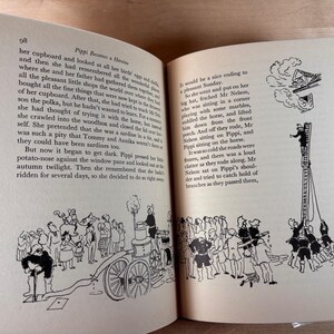 Puede incluir: Libro abierto con ilustraciones en blanco y negro. Una p&aacute;gina muestra una multitud cerca de una bomba de agua, la otra muestra a una persona subiendo una escalera. El texto es visible en ambas p&aacute;ginas, con el n&uacute;mero 98 en la parte superior de la p&aacute;gina izquierda.