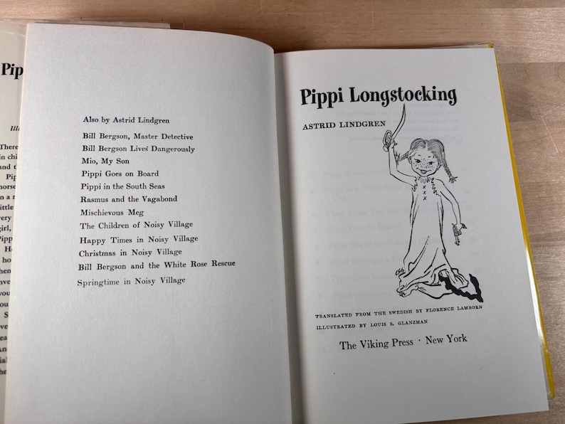 May include: An open hardcover book titled Pippi Longstocking by Astrid Lindgren. The left page lists other works by the author, while the right page features the title, author name, a black and white illustration of Pippi, and The Viking Press New York.