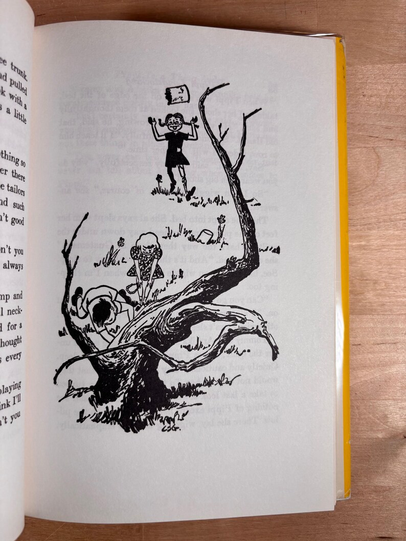 May include: A black and white book illustration depicting three children in a natural setting. One child stands near a large, gnarled tree, another climbs the trunk, and a third stands in the background with a small object floating above them.