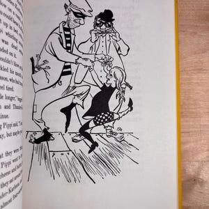 May include: A black and white line art illustration on a book page depicting a tall man in a striped shirt and cap, a man in a hat playing a harmonica, and a young girl with braided hair dancing together on a wooden floor with visible planks.