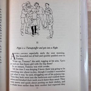 Puede incluir: Libro abierto con texto y una ilustraci&oacute;n en blanco y negro de ni&ntilde;os. La ilustraci&oacute;n muestra un grupo de ni&ntilde;os. El texto dice "Pippi is a Turnupstuffer and gets into a Fight".
