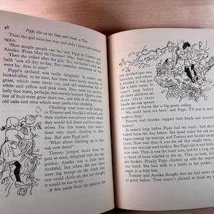 May include: An open hardcover book featuring black and white illustrations and printed text from the story Pippi Sits on the Gate and Climbs a Tree. The pages contain narrative paragraphs and line drawings of children climbing in an oak tree.