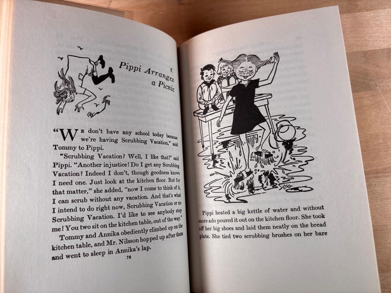 May include: An open book page featuring black and white illustrations of a character with braided hair scrubbing a floor. The text includes the chapter title Pippi Arranges a Picnic and narrative paragraphs describing Pippi, Tommy, and Annika.