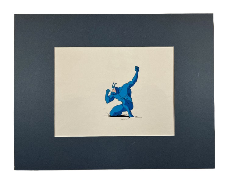 May include: A blue superhero character is kneeling with one arm raised in the air. The character is drawn in a cartoon style and is set against a white background.