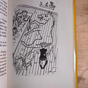 May include: A black and white book illustration showing a classroom scene with a child drawing a large horse outline on the wooden floorboards with a long piece of string. Other children sit at desks nearby, and text is visible on the left page.