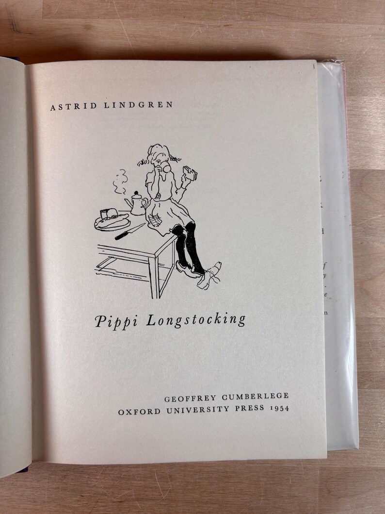 Puede incluir: P&aacute;gina de un libro con el t&iacute;tulo "Pippi Longstocking" de Astrid Lindgren. La p&aacute;gina presenta una ilustraci&oacute;n en blanco y negro de Pippi, una tetera y una mesa. Publicado por Geoffrey Cumberlege, Oxford University Press, 1954.