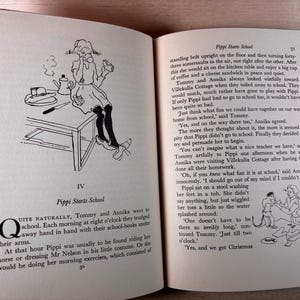 May include: An open book titled Pippi Starts School with black and white illustrations. The left page shows a girl sitting on a table with a coffee pot and sandwich. The right page contains printed text and a small drawing of a person in a tub.