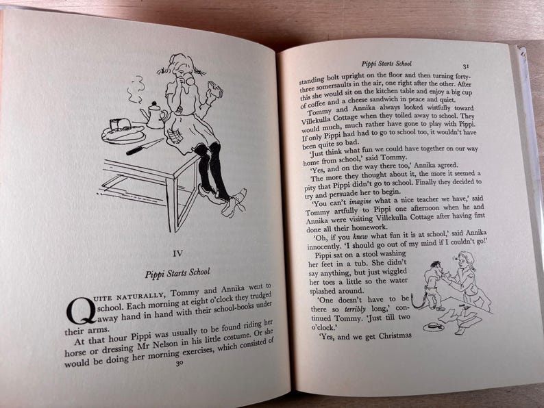 May include: An open book titled Pippi Starts School with black and white illustrations. The left page shows a girl sitting on a table with a coffee pot and sandwich. The right page contains printed text and a small drawing of a person in a tub.