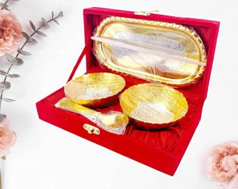 Puede incluir: Un juego de cuencos chapados en oro y una bandeja de servir en una caja de terciopelo rojo. Los cuencos y la bandeja tienen diseños intrincados y son perfectos para servir aperitivos o postres.