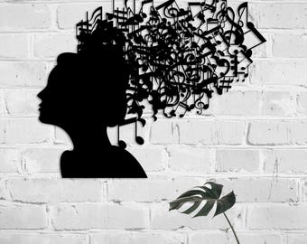 May include: A black metal wall art piece featuring the silhouette of a person in profile, with a dense, intricate cluster of musical notes, staves, and symbols extending from the head area to represent hair in a creative composition.