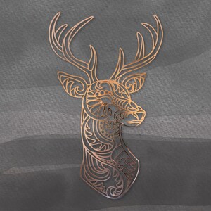 May include: A gold-colored deer silhouette with intricate patterns and designs. The deer's head is turned to the side, and its antlers are spread wide.