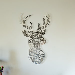 May include: A black metal deer head wall decor with intricate, detailed patterns. The deer head is a silhouette with a stylized design.