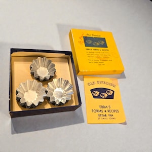 May include: A vintage baking set featuring three fluted metal forms inside a blue box. The set includes a yellow box and a recipe booklet labeled "Old Swedish" and "Ebba's Forms & Recipes".