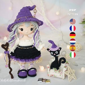 May include: A crochet doll with light skin, long wavy gray hair, and a purple witch hat, wearing a white blouse and black skirt. The doll holds a brown staff with a heart top. Beside it sits a small black cat in a purple hat on a floral chair.