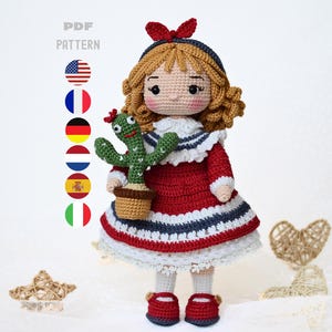 May include: A handmade crochet doll with blonde curly hair, wearing a red, white, and blue dress, holding a green cactus in a brown pot. The doll has red shoes and a red bow. The image includes the text "PDF PATTERN".