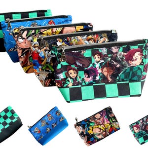 May include: A collection of zippered cosmetic bags with various anime character designs. The bags feature a black and green checkered pattern on the bottom and top, with different anime characters on the front.