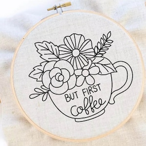 Peut inclure: Art de broderie sur un cercle avec un dessin au trait noir d'une tasse de café avec des fleurs et le texte "But First Coffee".