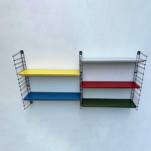 May include: A set of two black metal wall shelves with four shelves. The shelves are painted in different colours: yellow, blue, red, and green.