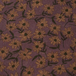 Peut inclure: Gros plan sur un tissu avec un motif floral r&eacute;p&eacute;t&eacute;. Les fleurs sont jaune dor&eacute; avec des centres fonc&eacute;s, sur un fond violet fonc&eacute;. Des feuilles et des tiges vert fonc&eacute; s'entrelacent avec les fleurs.