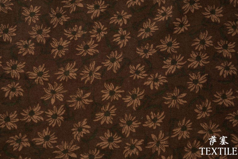 Peut inclure: Tissu textile marron avec un motif r&eacute;p&eacute;t&eacute; de fleurs stylis&eacute;es brun clair. Les fleurs sont dispers&eacute;es sur le fond brun fonc&eacute;. Le mot "TEXTILE" est imprim&eacute; en blanc.