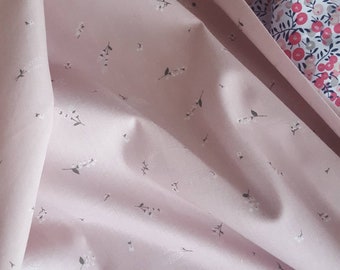 Tissu 100 % coton. Bouquets floraux à petite échelle sur fond rose foncé.