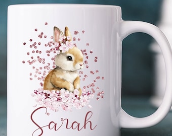 May include: White ceramic mug with a pink and brown bunny illustration and the name "Sarah" printed on the front.