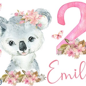 Könnte beinhalten: Eine Aquarell-Illustration eines Koalas, der eine rosa Blumenkrone mit Schmetterlingen trägt und die Zahl 2 mit rosa Blumen verziert ist. Der Name Emily ist in rosa unter der Zahl geschrieben.