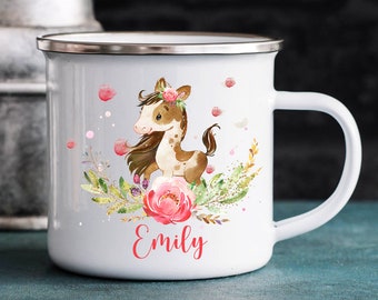 Könnte beinhalten: Weiße Emailtasse mit einer Illustration eines braunen und weißen Pferdes, rosa Blumen und goldenem Glitzer. Die Tasse hat einen silbernen Rand und einen Henkel. Der Name "Emily" ist unten in Rot geschrieben.