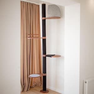 Könnte beinhalten: Ein hoher schwarzer Katzenbaum mit einem Sisalseil-Kratzbaum und mehreren Plattformen. Die Plattformen sind aus Holz und haben eine hellbraune Oberfläche. Der Katzenbaum hat ein graues Katzenbett auf der obersten Plattform.